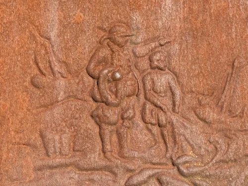 Antique hearth plate with old scene, vintage cast iron, rustic