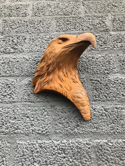 Adelaarskop, gietijzeren wandornament met een rustiek oppervlak
