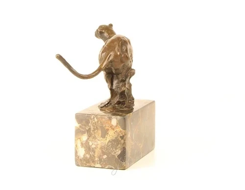 A bronze statue/sculpture of a running puma