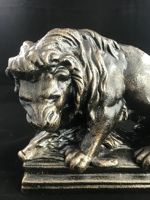 A beautiful statue of a lion with its prey, a boar, made of cast iron, bronze look!