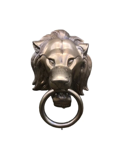 A lion's head, made of aluminum in a brass color, as a door knocker