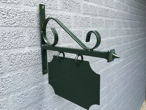 Store nameplate for old downtown, advertising sign made of metal, painted green.