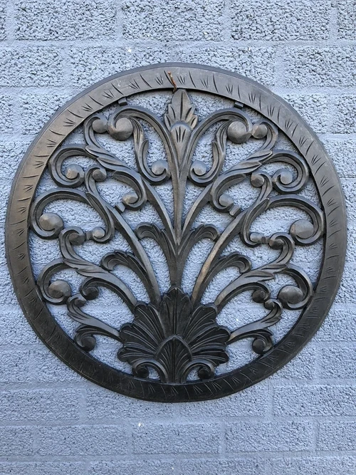 Wall ornament round, decoratively carved, black-brown.