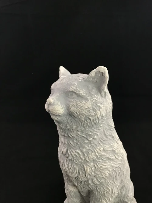 A beautiful sitting cat, made of stone, beautiful in detail