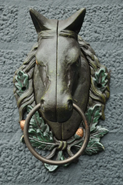 Paardenhoofd met ring, gietijzer bruin.