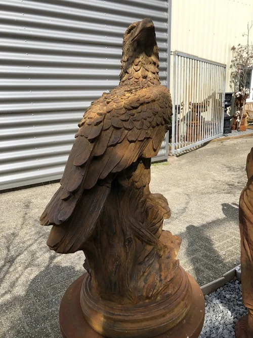 Gedetailleerd sculptuur van een adelaar zittend op een rots, gemaakt van oxid steen
